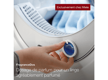 Charger l'image dans la galerie, Une main tourne un cadran de parfum bleu sur une machine à laver blanche, avec du tissu bleu à l'intérieur.