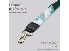 Charger l'image dans la galerie, Une lanière avec un motif floral, une pièce de cuir noir et un fermoir doré.