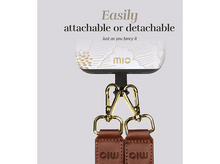 Charger l'image dans la galerie, Accessoire Mic blanc avec crochets dorés et lanières en cuir marron attachées.