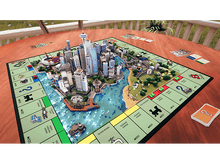 Charger l'image dans la galerie, Jeu de société Monopoly mis en place. Les bâtiments sont disposés sur un plateau de jeu sur le thème de la ville.