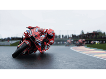 Charger l'image dans la galerie, Un coureur de moto rouge en course, sur une piste mouillée.