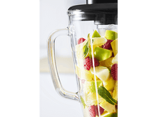 Charger l'image dans la galerie, Mixeur rempli de fruits coupés: pommes vertes, framboises et agrumes. Poignée en verre visible. Fond blanc.