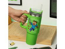 Charger l'image dans la galerie, Un gobelet vert sur le thème de Minecraft avec une paille, tenu par une main.