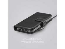 Charger l'image dans la galerie, Coque de téléphone en cuir noir sur un chargeur sans fil. Texte : Compatible avec le chargement sans fil.