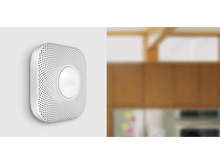 Charger l'image dans la galerie, Détecteur de fumée blanc sur un mur. Meubles en bois flous en arrière-plan.