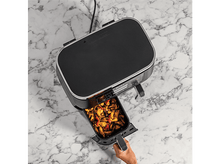 Charger l'image dans la galerie, Un friteuse à air Ninja avec un plateau rempli de nourriture cuite. Le plateau est en train d'être sorti. Surface en marbre.