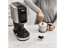 Charger l'image dans la galerie, Femme utilisant une machine à crème glacée Ninja. Il y a un bol avec de la crème glacée et des Oreo.