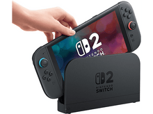Charger l'image dans la galerie, Main plaçant une Nintendo Switch dans son dock.