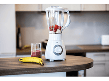 Charger l'image dans la galerie, Blender blanc avec fraises et banane. Verre de smoothie sur le côté.