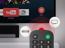 Charger l'image dans la galerie, Écran de télévision affichant YouTube, NBC, applications. Télécommande avec bouton vert et icônes.