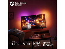 Charger l'image dans la galerie, Configuration de jeu avec TV montrant jeu de course. Manette sur la table. Jusqu'à 120Hz VRR.