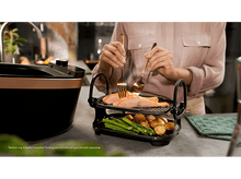 Charger l'image dans la galerie, Femme cuisinant du saumon sur un grill avec pommes de terre et asperges. Design grill cuivre et noir.