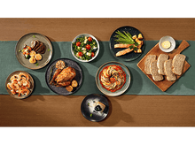 Charger l'image dans la galerie, Une table garnie de divers plats, dont de la viande, de la salade et du pain.