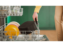 Charger l'image dans la galerie, Une personne place un panier de friteuse dans un lave-vaisselle.