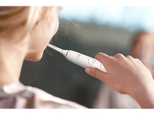 Charger l'image dans la galerie, Une personne se brosse les dents avec une brosse à dents Philips Sonicare blanche.