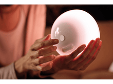 Charger l'image dans la galerie, Les mains d'une femme tenant une lampe sphérique blanche et brillante.