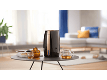 Charger l'image dans la galerie, Table avec un humidificateur, service à thé, livres et décoration dans un salon.