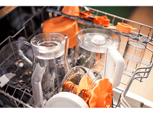 Charger l'image dans la galerie, Gros plan sur des ustensiles de cuisine dans un lave-vaisselle, avec des articles en plastique orange et transparent.