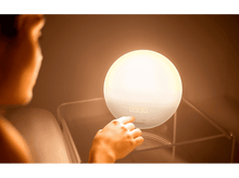 Charger l'image dans la galerie, Une personne touche un réveil Philips blanc avec une lueur vive.