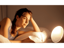 Charger l'image dans la galerie, Une femme est allongée sur un lit, à côté d'une horloge.