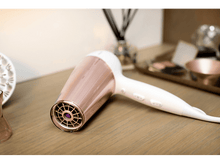 Charger l'image dans la galerie, Sèche-cheveux sur une surface en bois. Schéma de couleurs or rose et blanc.