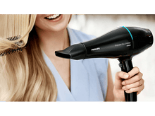 Charger l'image dans la galerie, Femme utilisant un sèche-cheveux noir sur des cheveux blonds.