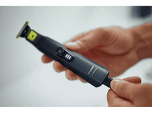 Charger l'image dans la galerie, Homme tenant une tondeuse Philips OneBlade noire et vert citron.