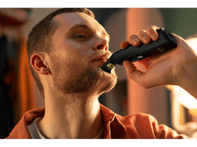 Charger l'image dans la galerie, Homme utilisant une tondeuse à barbe Philips noire et jaune.
