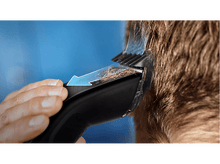 Charger l'image dans la galerie, Gros plan de cheveux coupés avec une tondeuse noire. Une flèche bleue indique la direction de la coupe.