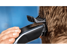 Charger l'image dans la galerie, Une personne utilisant une tondeuse pour couper les cheveux à l'arrière de la tête de quelqu'un.