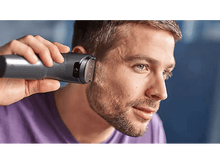 Charger l'image dans la galerie, Un homme taillant sa barbe avec une tondeuse à barbe Philips, gros plan.