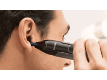Charger l'image dans la galerie, Un homme se coupant les poils des oreilles avec un appareil Philips noir et bleu.