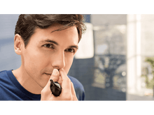 Charger l'image dans la galerie, Un homme se coupe les poils du nez avec un coupe-nez noir.