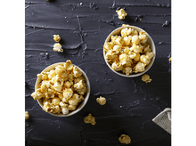 Charger l'image dans la galerie, Deux bols de pop-corn sur surface noire texturée. Pop-corn éparpillé. Petit chiffon blanc.