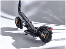 Charger l'image dans la galerie, Une trottinette électrique grise avec un guidon noir et un feu arrière, sur fond blanc.
