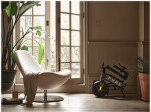 Charger l'image dans la galerie, Une pièce avec un scooter, une chaise et des plantes. Le scooter porte la mention 'PURE'.