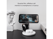 Charger l'image dans la galerie, Téléphone sur un socle de chargement. Un homme regarde une vidéo, statue à côté.