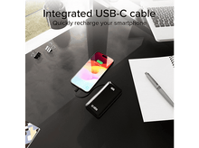 Charger l'image dans la galerie, Batterie externe noire chargeant un téléphone sur un bureau avec un stylo et du papier.