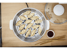 Charger l'image dans la galerie, Cuiseur vapeur avec raviolis, sauce soja et baguettes.