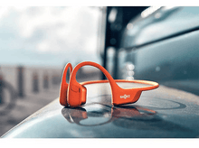 Charger l'image dans la galerie, Casque sans fil orange sur une surface sombre.