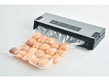 Charger l'image dans la galerie, Scelleuse sous vide avec un sac d'aliments précuits, scellés, de couleur orange.