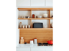 Charger l'image dans la galerie, Cuisine moderne avec étagères en bois contenant des objets ; comptoir en marbre et théière rouge.