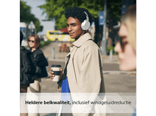 Charger l'image dans la galerie, Homme avec casque, marchant dans la rue, portant un manteau beige.