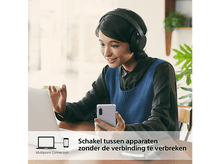 Charger l'image dans la galerie, Femme utilisant un ordinateur portable, tenant un téléphone, avec un casque.