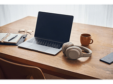 Charger l'image dans la galerie, Un bureau en bois avec un ordinateur portable, un casque, une tasse, un carnet, des lunettes et un téléphone. Chaise en bois.
