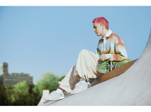 Charger l'image dans la galerie, Jeune homme aux cheveux roses assis sur une rampe de skate, portant des écouteurs et des vêtements décontractés.