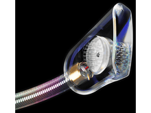 Charger l'image dans la galerie, Gros plan sur un écouteur transparent, mettant en évidence les composants internes et un câble métallique, sur fond noir.