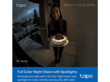 Charger l'image dans la galerie, Femme tenant un gâteau la nuit, enregistrée par une caméra de sécurité. La scène montre une maison.