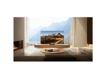 Charger l'image dans la galerie, Salon avec TV affichant une scène de montagne, près d'une cheminée et fenêtre.