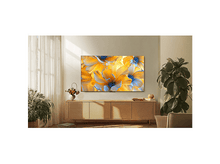 Charger l'image dans la galerie, Écran de télévision avec image de fleurs, sur meuble en bois. Rideau blanc et plante.